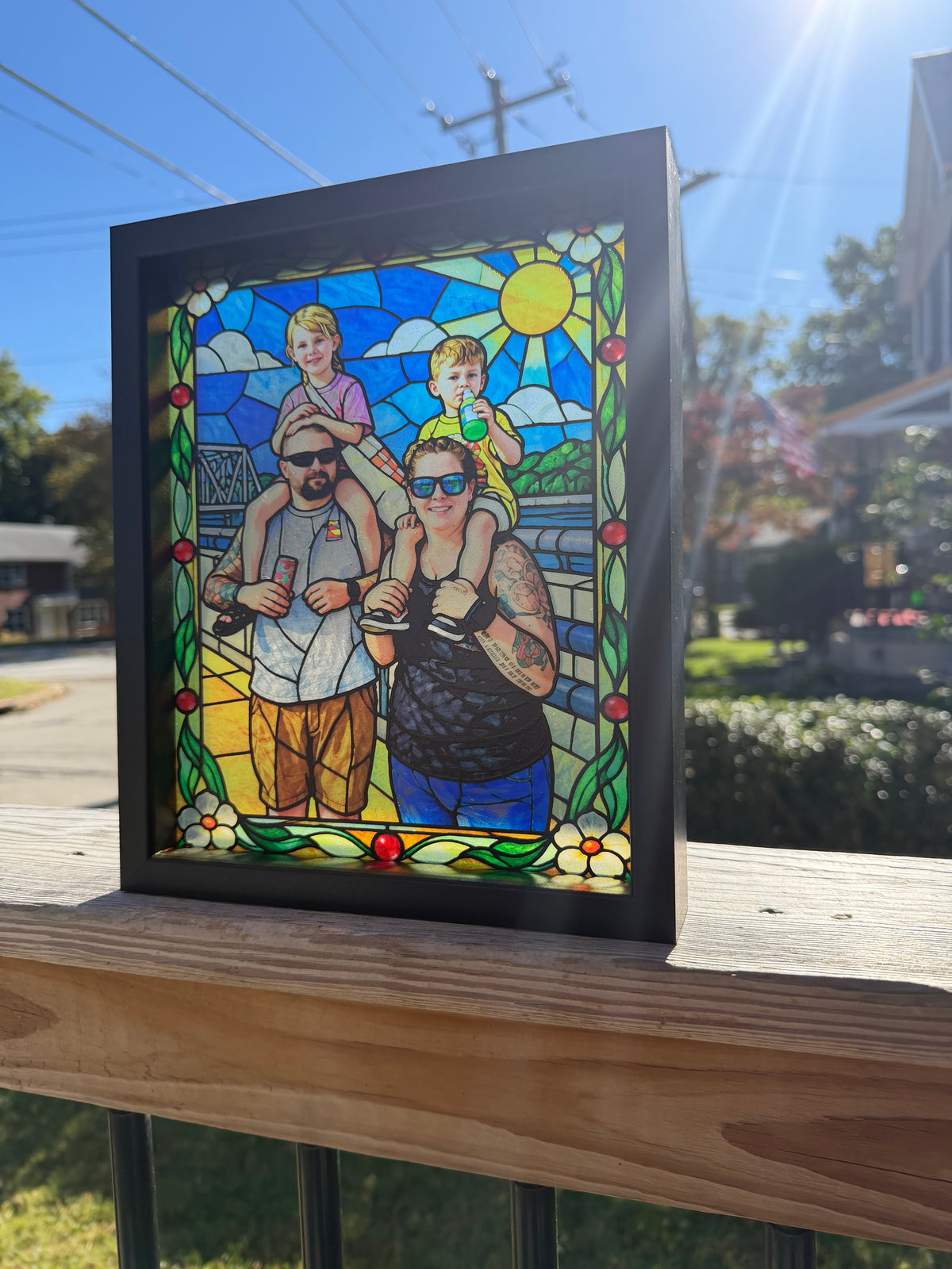 Custom 8x10 simulated stained glass family photo art UV printed on translucent acrylic in a black frame outdoors.